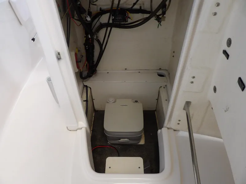 Slide: The Image of 2020 Robalo R180 boat interior with portable toilet and wiring. - 13