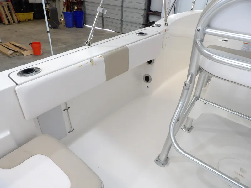 Slide: The Image of 2020 Robalo R180 boat interior with seating and rod holders in a garage setting. - 16