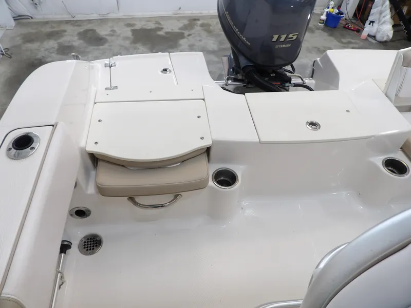Slide: The Image of 2020 Robalo R180 boat interior with Yamaha 115 engine, featuring storage compartments and cup holders. - 22
