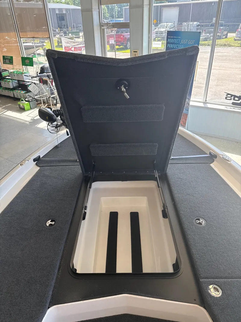 Slide: The Image of 2025 Skeeter ZXR20SE boat storage compartment open in showroom. - 19