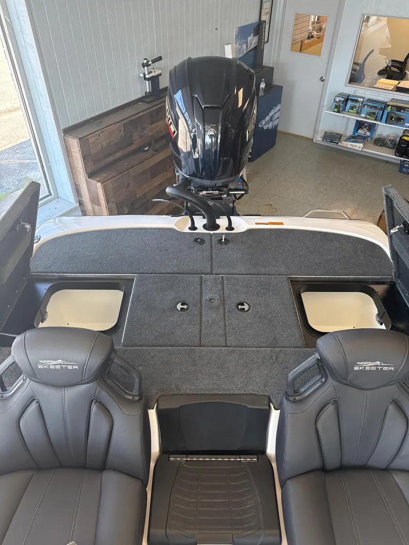 Slide: The Image of 2025 Skeeter ZXR20SE boat interior with dual seats and motor in showroom. - 27