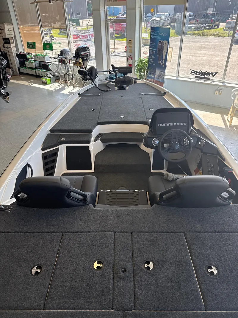 Slide: The Image of 2025 Skeeter ZXR20SE boat interior with steering console and seating in showroom. - 28