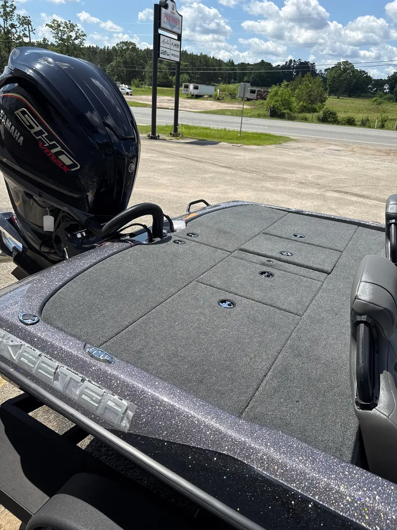 Slide: The Image of 2025 Skeeter ZXR21SE boat with Yamaha engine, parked outdoors under a sunny sky. - 11