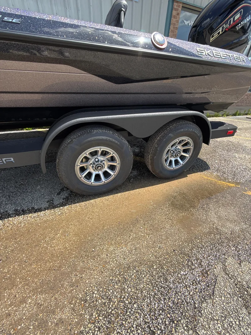 Slide: The Image of 2025 Skeeter ZXR21SE boat on a dual-axle trailer, parked on asphalt. - 6