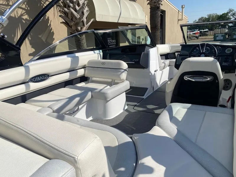 Slide: The Image of 2018 Cobalt CS23 Surf boat interior with white seating and modern dashboard. - 13