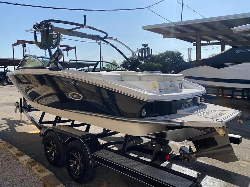 Slide: The Image of 2018 Cobalt CS23 Surf boat on trailer in a marina setting. - 5