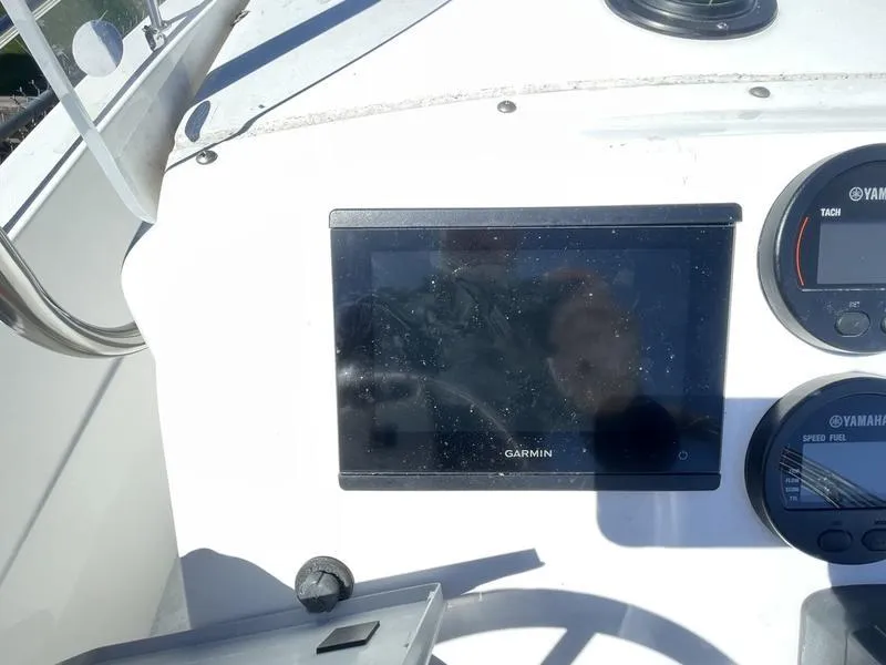 Slide: The Image of 2022 Edgewater 170CC boat dashboard with Garmin navigation system and Yamaha gauges. - 2