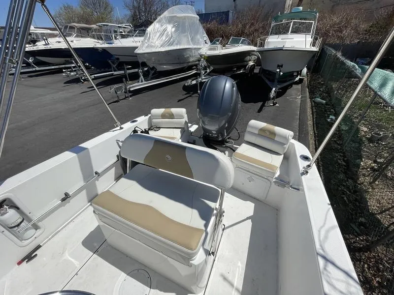 Slide: The Image of 2022 Edgewater 170CC boat with seating, parked among other boats in a lot. - 3