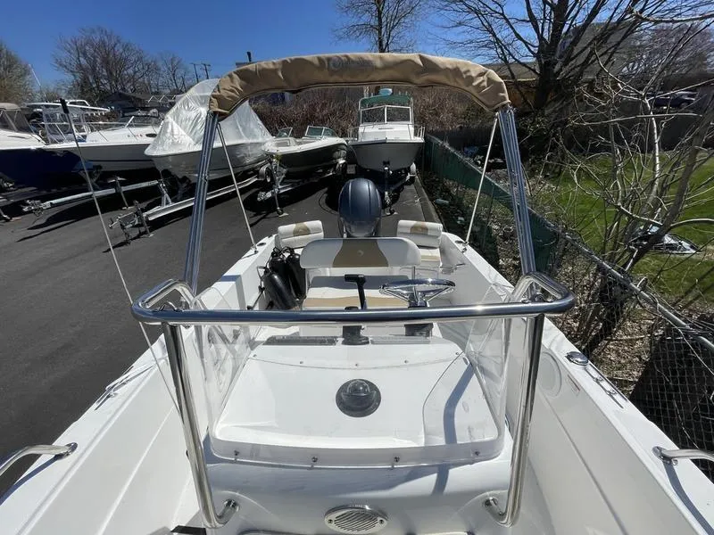 Slide: The Image of 2022 Edgewater 170CC boat with canopy, docked among other boats, sunny day. - 4