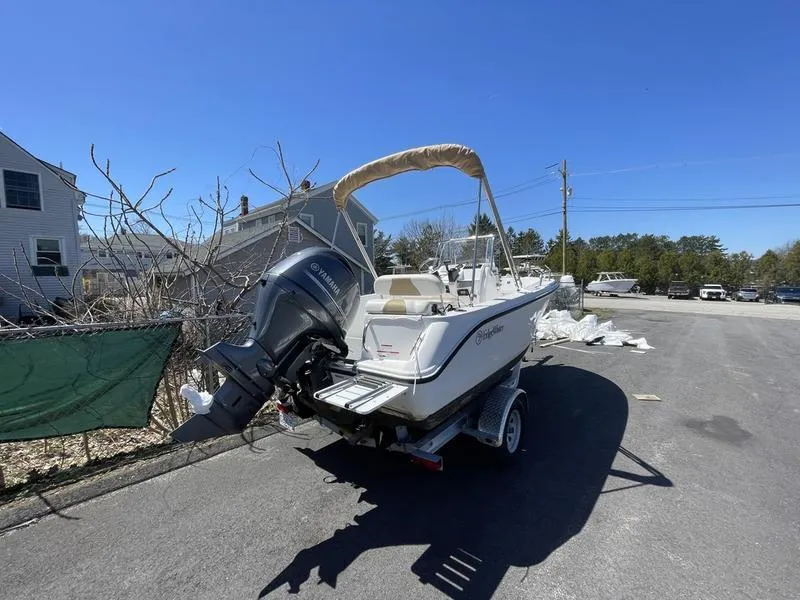 Slide: The Image of 2022 Edgewater 170CC boat on trailer, parked outdoors under clear blue sky. - 6