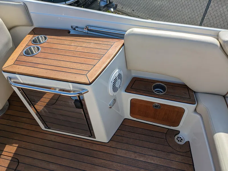 Slide: The Image of 2008 Chris-Craft Corsair 25 boat interior with wooden deck and seating area. - 11