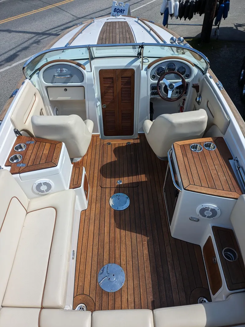 Slide: The Image of 2008 Chris-Craft Corsair 25 boat interior with teak flooring and beige seating. - 12