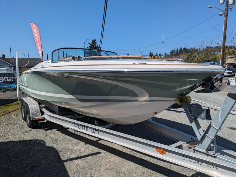 Slide: The Image of 2008 Chris-Craft Corsair 25 boat on trailer, displayed outdoors under clear sky. - 2