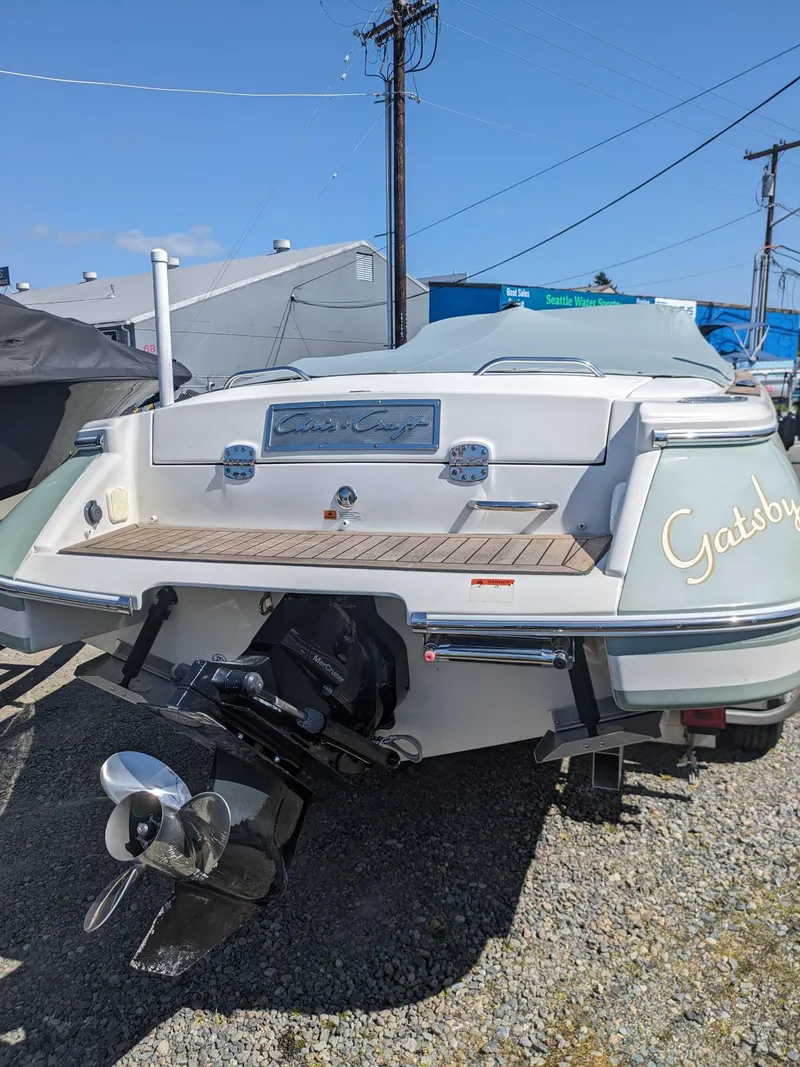 Slide: The Image of 2008 Chris-Craft Corsair 25 boat, rear view, parked on gravel, with visible propeller. - 3