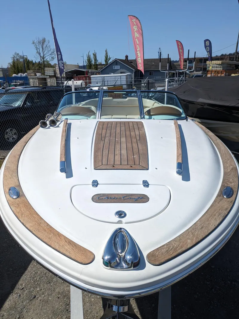 Slide: The Image of 2008 Chris-Craft Corsair 25 boat with wooden deck, displayed outdoors. - 4