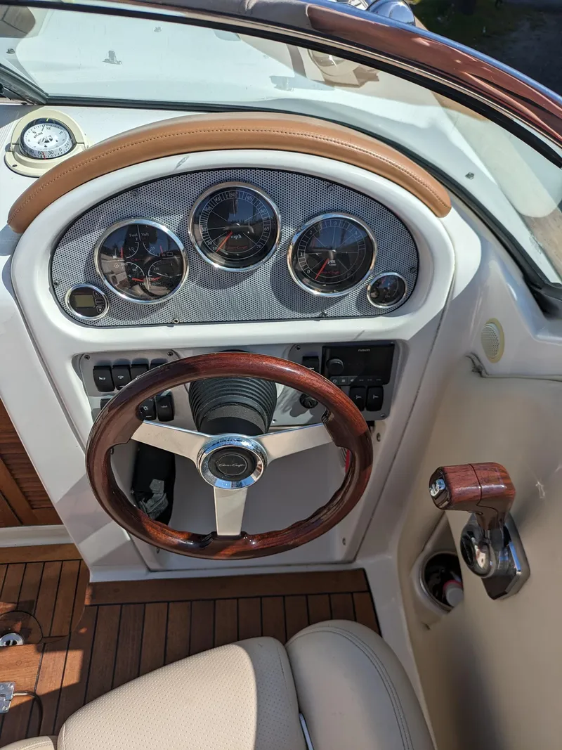 Slide: The Image of 2008 Chris-Craft Corsair 25 dashboard with wood steering wheel and classic gauges. - 7