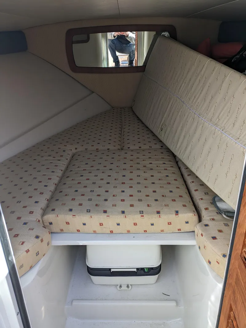 Slide: The Image of 2008 Chris-Craft Corsair 25 cabin interior with patterned cushions and compact storage. - 9