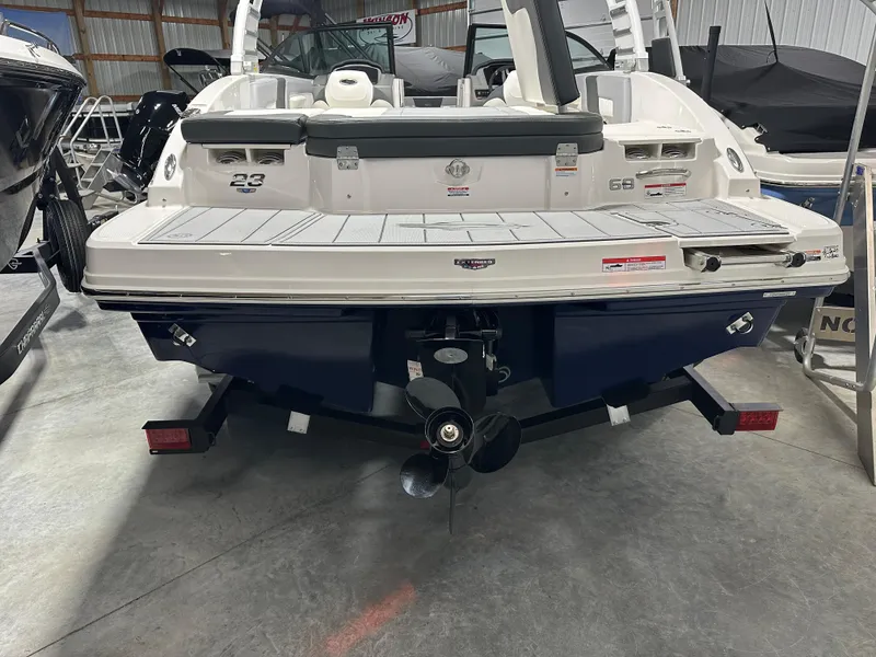 Slide: The Image of 2025 Chaparral 23 SSi boat, rear view in a showroom, showcasing sleek design and powerful engine. - 3