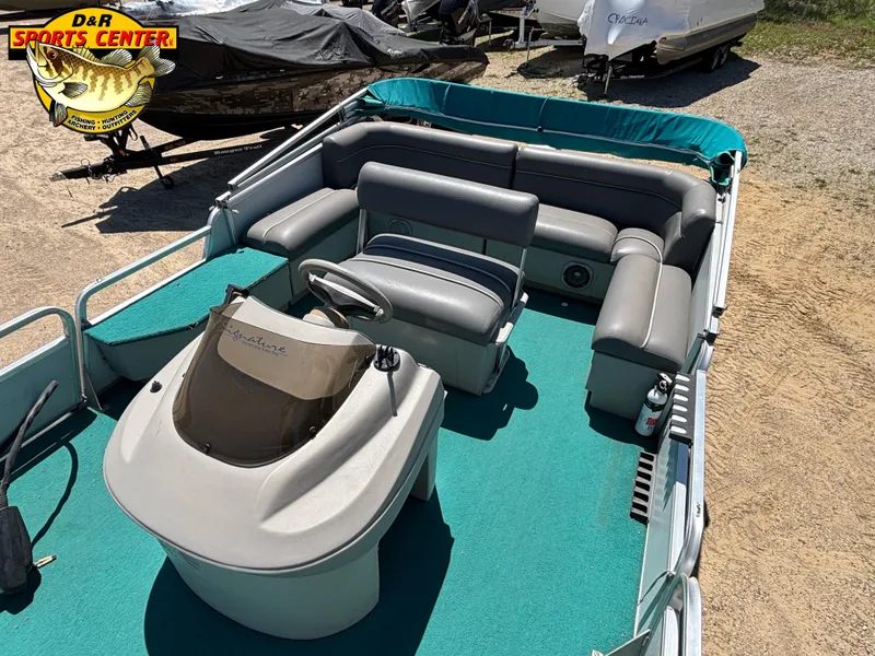 Slide: The Image of 1997 Sun Tracker BASS BUGGY 18 CC pontoon boat with teal carpet and gray seating. - 5