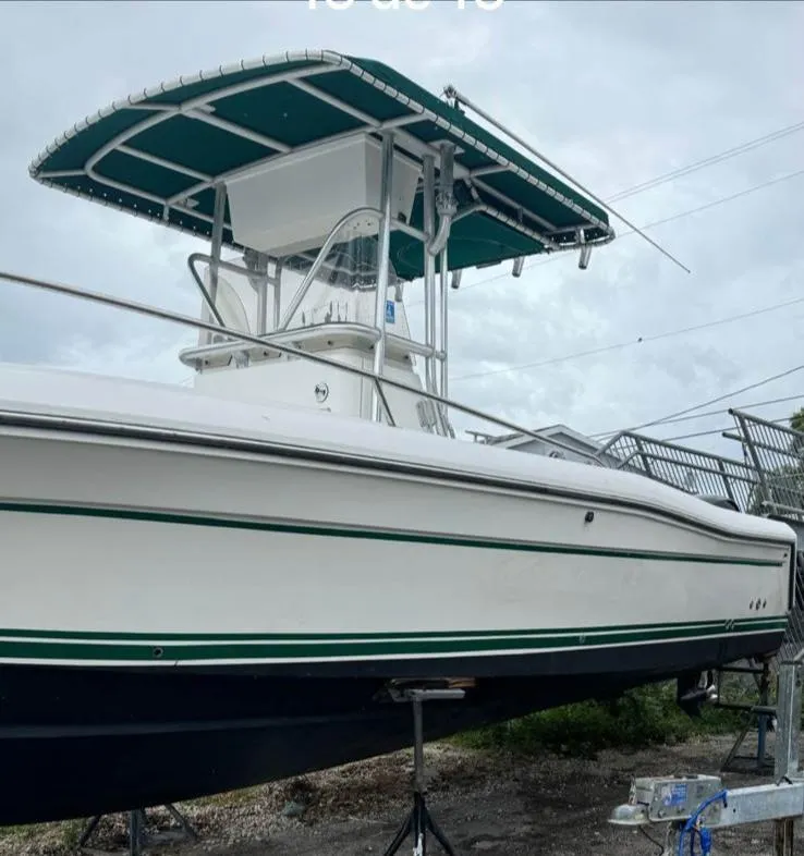 Slide: The Image of 2000 Stamas 250 Tarpon boat with T-top, docked on land, side view. - 10