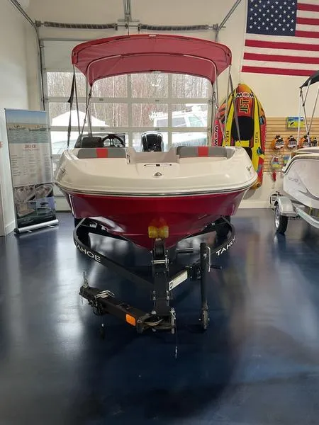 Slide: The Image of 2025 Tahoe T16 boat with red canopy displayed indoors, American flag in background. - 0