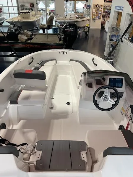 Slide: The Image of 2025 Tahoe T16 boat interior with steering wheel and seating in showroom. - 1
