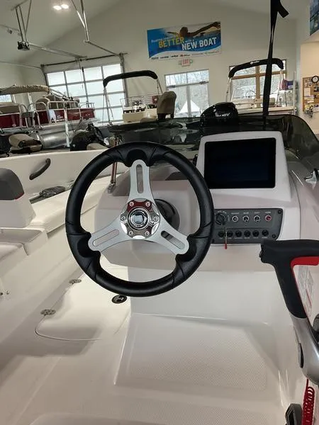 Slide: The Image of 2025 Tahoe T16 boat interior with steering wheel and control panel in showroom. - 3
