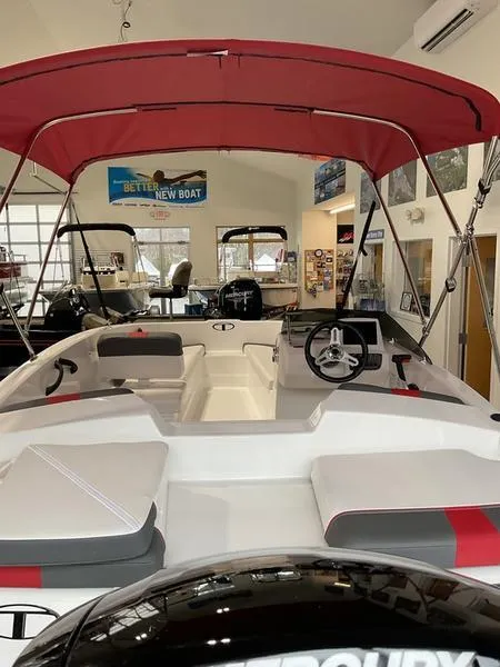 Slide: The Image of 2025 Tahoe T16 boat with red canopy in showroom, featuring modern seating and steering wheel. - 4
