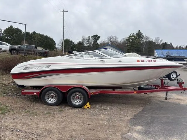 Slide: The Image of 2002 Ebbtide 210 Campione boat on red trailer, parked outdoors. - 1