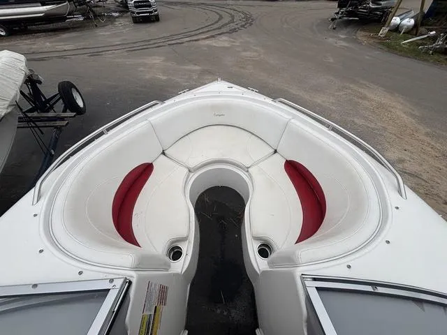 Slide: The Image of 2002 Ebbtide 210 Campione boat with white and red seating, parked on a lot. - 14