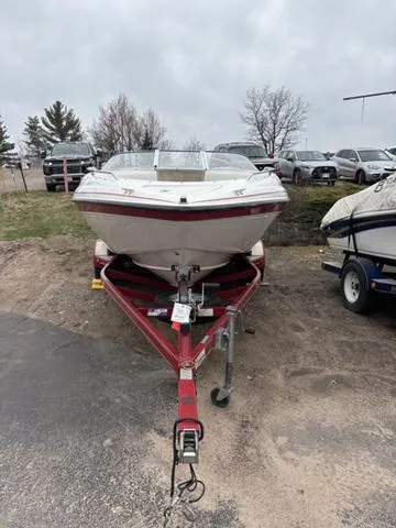 Slide: The Image of 2002 Ebbtide 210 Campione boat on red trailer, parked outdoors. - 3