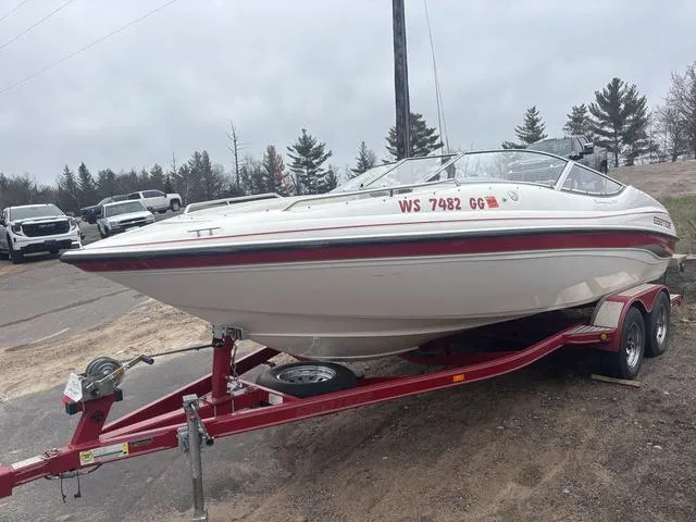 Slide: The Image of 2002 Ebbtide 210 Campione boat on red trailer, parked outdoors. - 4
