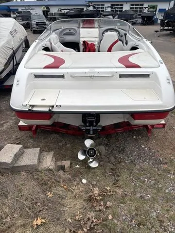 Slide: The Image of 2002 Ebbtide 210 Campione boat, rear view, white with red accents, parked outdoors. - 6