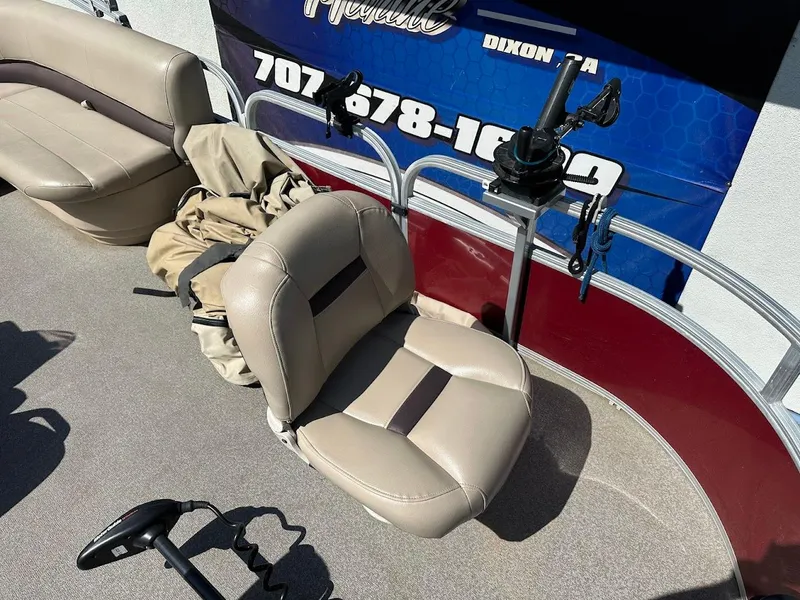 Slide: The Image of 2019 Sun Tracker Bass Buggy 18 DLX boat interior with beige seating and fishing rod holders. - 11