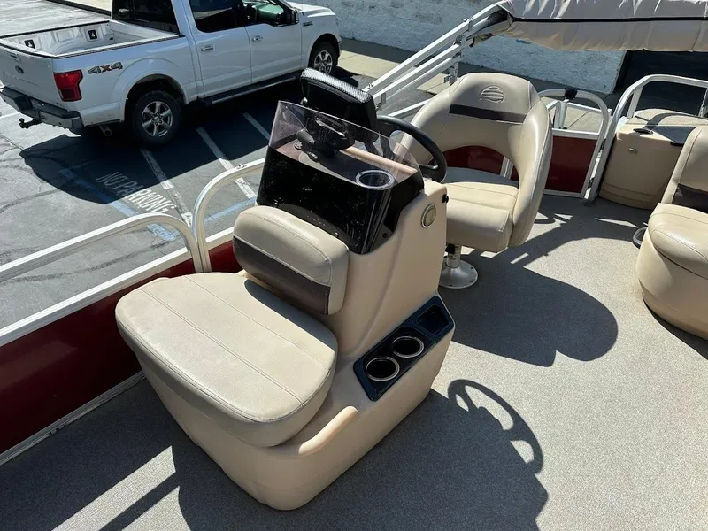 Slide: The Image of 2019 Sun Tracker Bass Buggy 18 DLX interior with beige seating and steering console. - 16