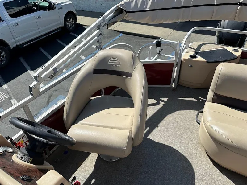 Slide: The Image of 2019 Sun Tracker Bass Buggy 18 DLX boat interior with beige seating and steering wheel. - 20