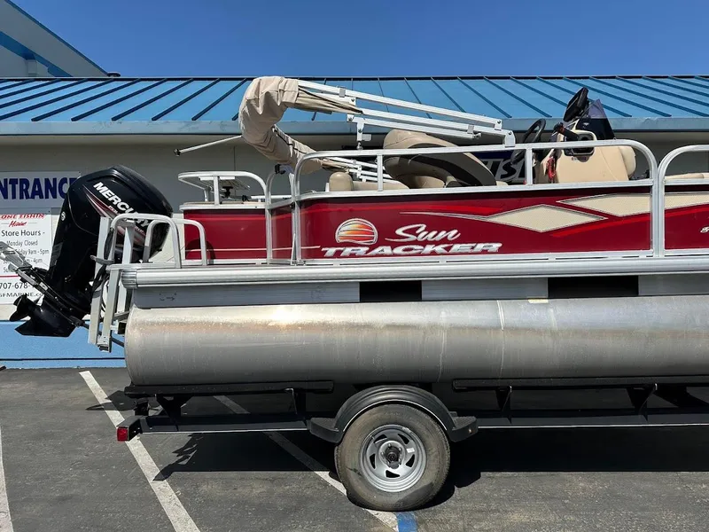 Slide: The Image of 2019 Sun Tracker Bass Buggy 18 DLX pontoon boat on trailer, parked outdoors. - 5