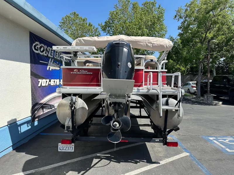 Slide: The Image of 2019 Sun Tracker Bass Buggy 18 DLX pontoon boat parked outdoors. - 7