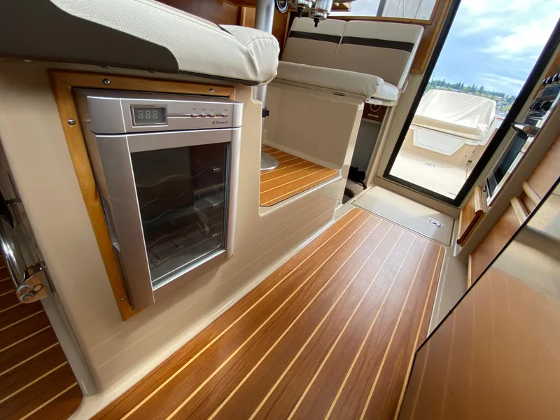 Slide: The Image of Interior of a 2017 Cutwater C-28 boat with wood flooring and compact fridge. - 11