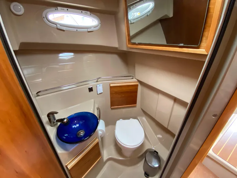 Slide: The Image of 2017 Cutwater C-28 boat bathroom with blue sink, toilet, and wooden accents. - 17