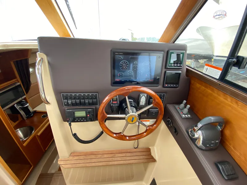 Slide: The Image of 2017 Cutwater C-28 helm with wooden steering wheel and modern navigation controls. - 22
