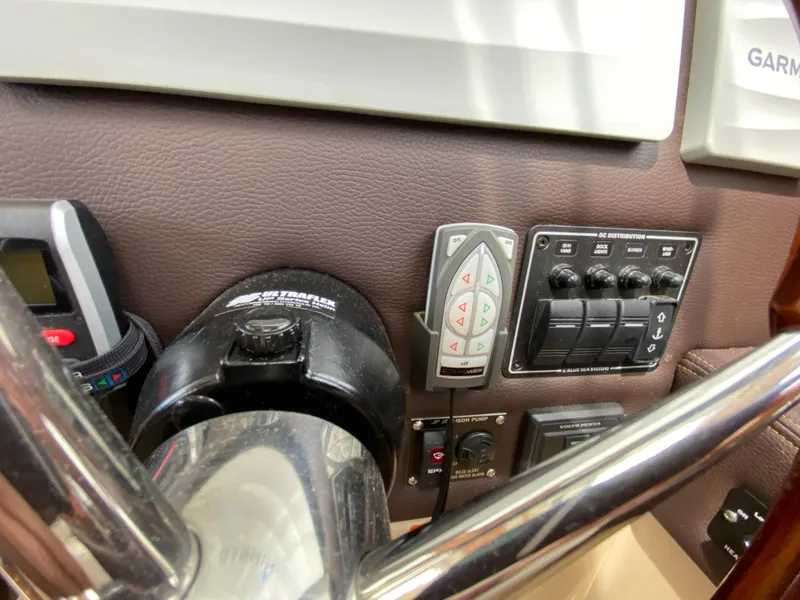 Slide: The Image of Control panel of a 2017 Cutwater C-28 boat with various switches and instruments. - 28