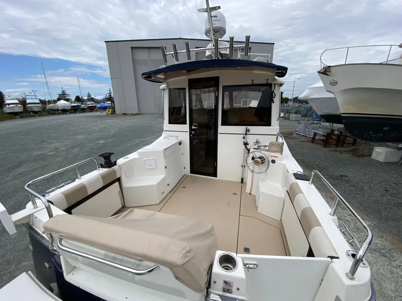 Slide: The Image of 2017 Cutwater C-28 boat with spacious deck and seating, docked near a storage facility. - 36