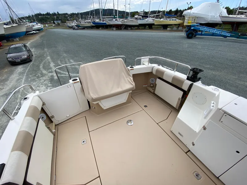 Slide: The Image of 2017 Cutwater C-28 boat deck with seating, docked near other boats. - 37