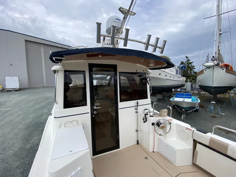 Slide: The Image of 2017 Cutwater C-28 boat docked, showcasing rear deck and cabin entrance. - 38