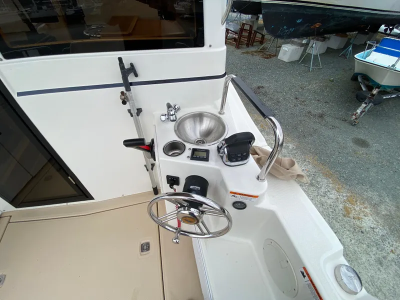 Slide: The Image of 2017 Cutwater C-28 boat helm with steering wheel, sink, and control panel. - 39