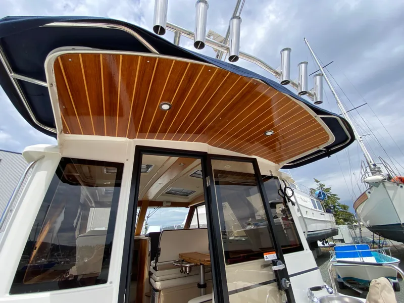 Slide: The Image of 2017 Cutwater C-28 boat with wooden ceiling and sleek design, docked under cloudy skies. - 40