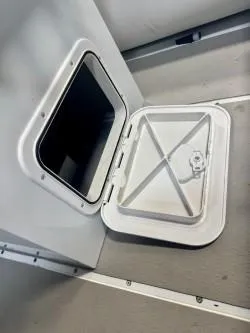 Slide: The Image of Open storage compartment on 2025 Inmar 430R-AL boat, featuring a secure hatch design. - 9