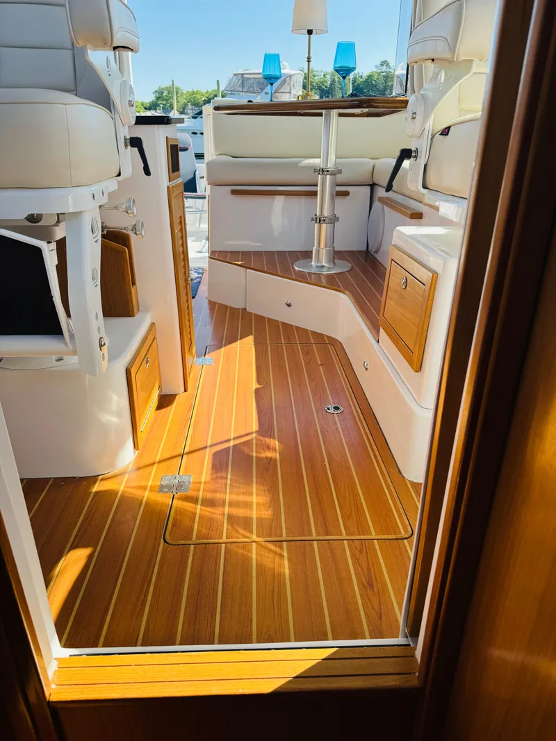 Slide: The Image of 2024 True North 34 Outboard Express interior with wood flooring and seating area. - 15