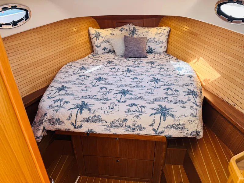 Slide: The Image of Cozy cabin interior of 2024 True North 34 Outboard Express with nautical-themed bedding. - 16